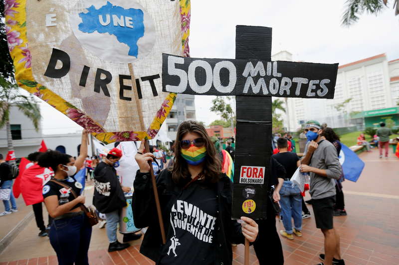 A person holds a cross reading "500.000 deaths" as people participate in a protest against Brazils President Jair Bolsonaro and his handling of the coronavirus disease (COVID-19) pandemic in Cuiaba, Brazil, June 19, 2021. REUTERS/Mariana Greif